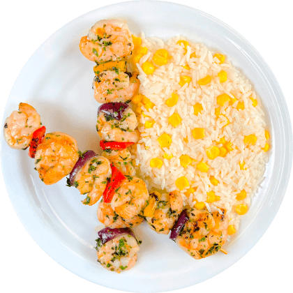 Brochetas de camarón con arroz con choclo.